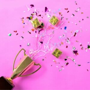 Picture of a gold trophy laying on its side with confetti spilling out.